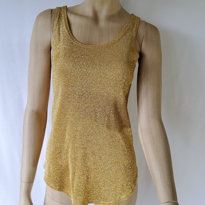 以下が含まれることがあります： 丸首のゴールドメタリックタンクトップ。トップは細かいニット生地で作られています。