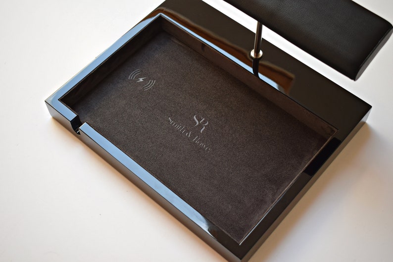 May include: Black valet tray with a wireless charging pad and a watch stand. The tray has a black velvet lining and the text "Smith & Ross" is embossed on the bottom.