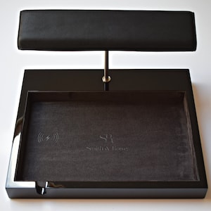 May include: Black valet tray with a wireless charging pad and a leather watch stand. The tray has a gray felt lining and the text "Smith & Jones" is embossed on the felt.
