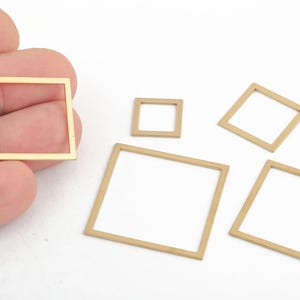 May include: Four gold-colored metal square frames of different sizes. The frames are open and have a smooth, polished finish.
