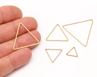 May include: A selection of gold-coloured triangle-shaped jewellery findings. The findings vary in size, with one held in a hand. The triangles are made of thin wire and are displayed against a white background. Suitable for jewellery making.