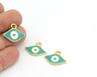 Puede incluir: Tres abalorios de metal dorado en forma de ojo turco. Los ojos son azules, blancos y turquesa.