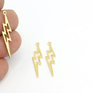 May include: Three gold-colored metal lightning bolt charms with a loop at the top for attaching to jewelry or other crafts.