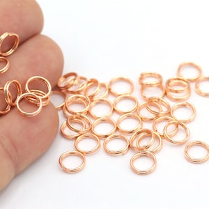 May include: A pile of small, gold-toned jump rings. The rings are about 6mm in diameter and are perfect for jewelry making.