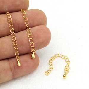 May include: Two gold chain extenders with a teardrop-shaped end. The extenders are approximately 2 inches long.