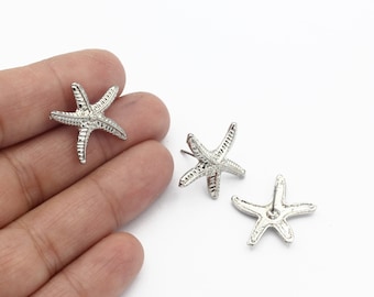May include: A pair of silver starfish stud earrings. The earrings are small and delicate, with a simple design.
