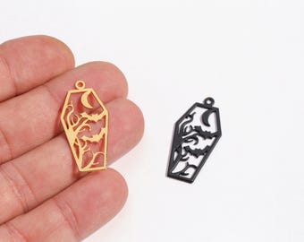 May include: Two coffin-shaped pendants, one gold and one black, with a cutout design featuring a crescent moon, bats, and stylized branches. These Halloween-themed charms are ideal for jewelry making.