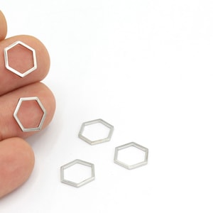 May include: Five silver-toned metal hexagonal rings. The rings are open and have a smooth, polished finish.