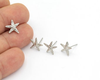 May include: Four silver starfish stud earrings. The earrings are small and delicate, with a textured surface.