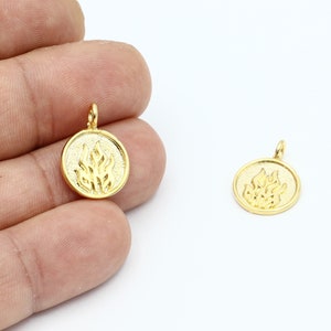 May include: Two gold-toned metal charms in the shape of a circle with a raised flame design.