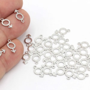 May include: A group of silver metal charms in the shape of the male gender symbol. The charms have a small loop at the top for attaching to jewelry or other crafts.