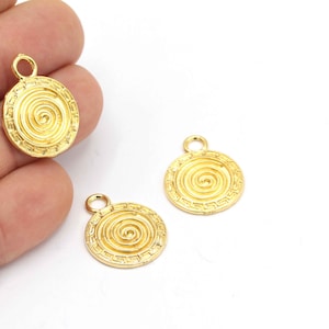 Puede incluir: Tres abalorios de metal dorado con un diseño en espiral. Cada abalorio tiene un bucle en la parte superior para sujetarlo a un collar o pulsera.