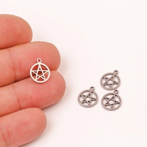 May include: Four silver-toned metal charms in the shape of a pentacle, or five-pointed star. The charms are about 1 inch in diameter and have a hole at the top for attaching to a necklace or bracelet.