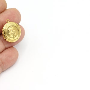 Op de afbeelding: Een gouden hanger met een reliëf bloemmotief. De hanger is rond met een getextureerde rand.