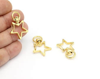 May include: Two gold-toned star-shaped keyrings with a swivel clasp. The keyrings are made of metal and have a shiny finish.