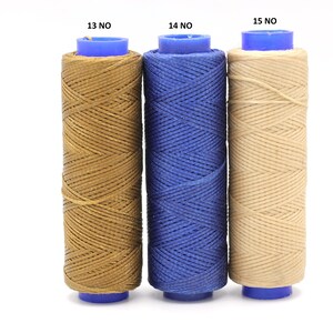May include: Three spools of waxed thread, each in a different colour: brown, blue, and beige. The spools are labelled with the numbers 13, 14, and 15.