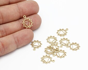 May include: A group of gold-colored metal charms featuring a sun with a triangle inside. The charms have a small loop at the top for attaching to jewelry.