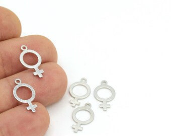 Puede incluir: Cinco dijes de metal plateado en forma de símbolo femenino.
