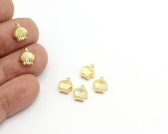 May include: Six gold-colored metal seashell charms with a loop for attaching to jewelry or other crafts.
