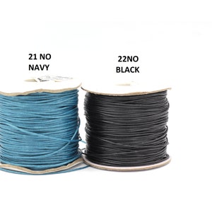 May include: Two spools of waxed cord, one navy blue and one black. The spools are labeled "21 NO NAVY" and "22 NO BLACK".