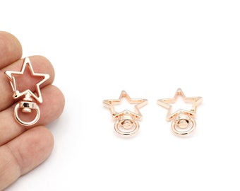 May include: Three gold-tone star-shaped keyrings with a swivel ring and a small round loop.