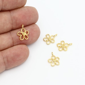 Könnte beinhalten: Vier goldfarbene Metall-Blumenanhänger mit einem Wirbeldesign in der Mitte. Die Anhänger haben einen Durchmesser von etwa 2,5 cm.
