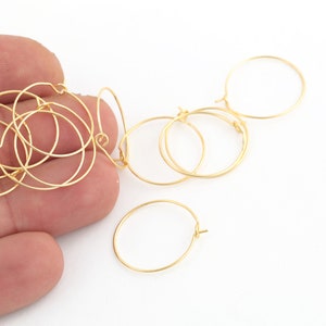 Peut inclure: Gros plan sur un tas de boucles d'oreilles créoles dorées. Les boucles d'oreilles sont en fil fin et ont un design simple et élégant.