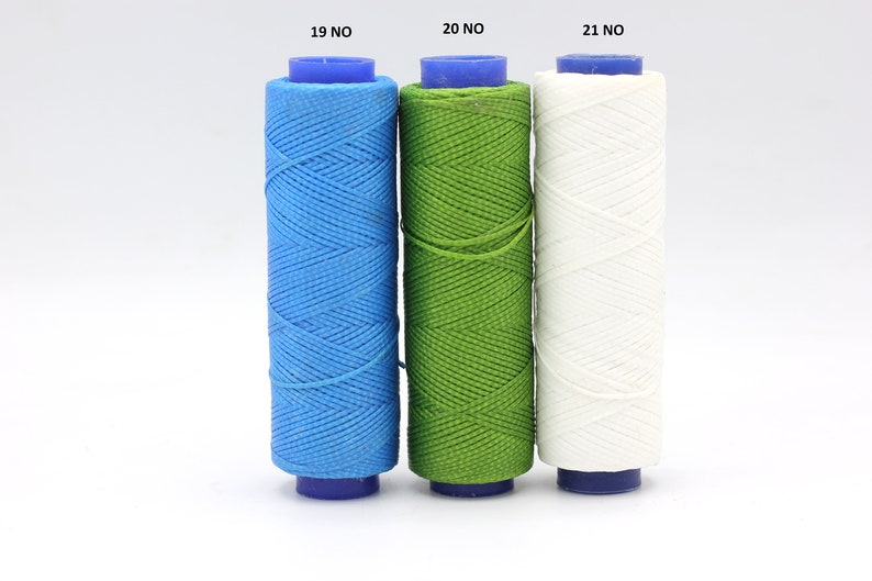May include: Three spools of thread, one blue, one green, and one white. The spools are labelled 19 NO, 20 NO, and 21 NO.