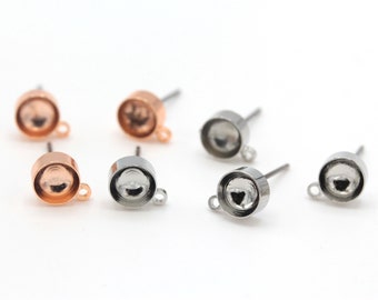 May include: Six earring settings, three silver and three rose gold, with a round bezel and a loop for attaching a charm or pendant.