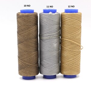 May include: Three spools of thread in brown, grey, and beige colours. The spools are labelled 10 NO, 11 NO, and 12 NO.