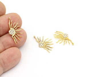 Può includere: Tre ciondoli dorati a forma di sole con accenti di cristallo trasparente. Ogni ciondolo ha un anello per attaccarlo a un gioiello.