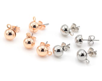 May include: A set of six earring findings with a round ball shape. Three are gold-toned and three are silver-toned. Each finding has a loop at the top for attaching a charm or pendant.
