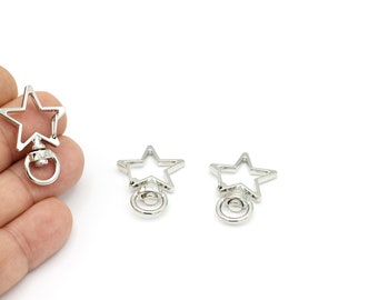 May include: Three silver star-shaped keyrings with a swivel clasp. Each keyring has a round ring attached to the bottom.