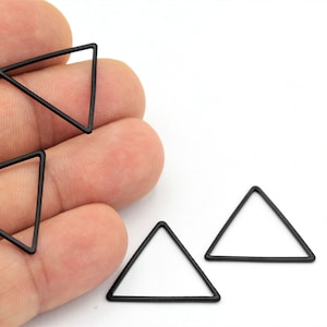 May include: Four black metal triangle shapes, each with a hollow center.