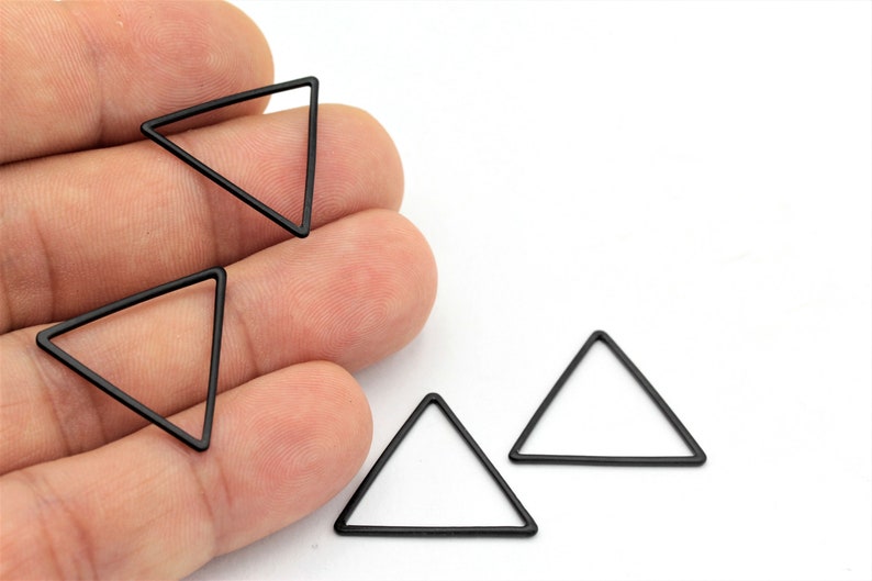 May include: Four black metal triangle shapes, each with a hollow center.