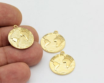 May include: Three gold-colored metal charms shaped like the Earth. Each charm has a raised, textured design of the continents and oceans. The charms have a loop at the top for attaching to a necklace or bracelet.