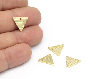 May include: Four gold-coloured triangle-shaped metal charms with a textured surface and a small hole at the top.