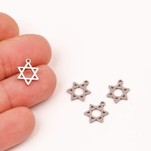 Op de afbeelding: Vier zilveren Davidster-bedels met een lus om aan sieraden of andere knutselwerkjes te bevestigen.