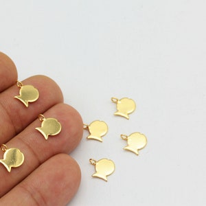 May include: Several small, gold-colored fish-shaped charms with a loop at the top for attaching to jewelry. The charms are scattered on a white surface. The fish charms are a simple, minimalist design.