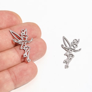 May include: Two silver-colored fairy charms. The charms are in the shape of a fairy with outstretched arms and wings. The fairy charms are on a white background.