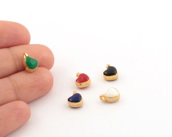May include: Five gold heart-shaped charms with different coloured enamel inlays. The charms are green, red, black, white, and blue.