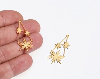 May include: Gold-colored starburst charm pendants. Each pendant features a geometric design with multiple star shapes. The pendants are shown against a white background. These charms are suitable for jewelry making.