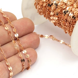 May include: A spool of rose gold chain with small round discs. The chain is delicate and would be perfect for jewelry making.