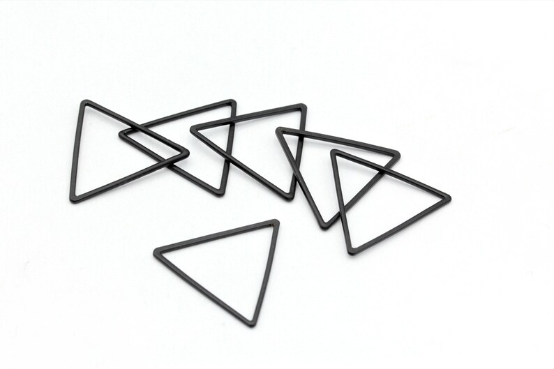 May include: Six black metal triangle shapes, some overlapping, on a white background. The triangles are all the same size and shape.