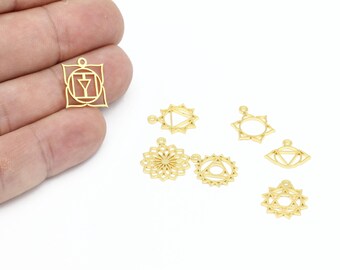 May include: Seven gold-colored metal charms with different designs, including a square, circles, and a flower. The charms are all about 1 inch in diameter and have a hole at the top for attaching to a chain or bracelet.