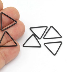 May include: A set of six black triangle-shaped metal rings. The rings are about 1 inch in diameter.