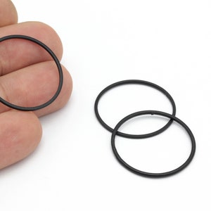 May include: Three black metal rings, two of which are stacked on top of each other.