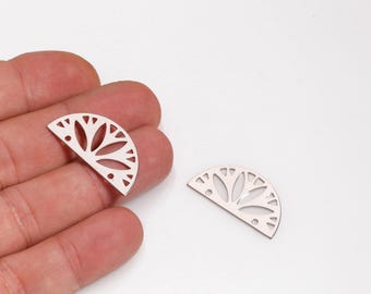 May include: Two silver-colored, half-circle shaped jewelry components with a floral design. The components have cut-out details and are displayed on a white background. One is held in a hand, and the other is lying on the surface.