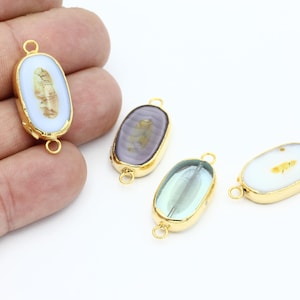 May include: Four oval-shaped gemstone pendants with gold-toned metal accents. Each pendant features a different color and pattern of gemstone.