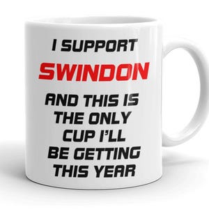 May include: White ceramic mug with the text "I SUPPORT SWINDON" in black and red. The mug reads "AND THIS IS THE ONLY CUP I'LL BE GETTING THIS YEAR". The mug has a curved handle. A gift idea.